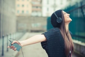 relaxation: Girl with outstretched arms listening to music on her phone