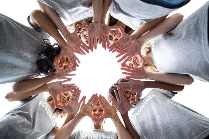 career in community services: worm's eye view of women with their hands together in a circle