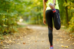 negative emotions: girl stretching to prepare herself for a run in the park