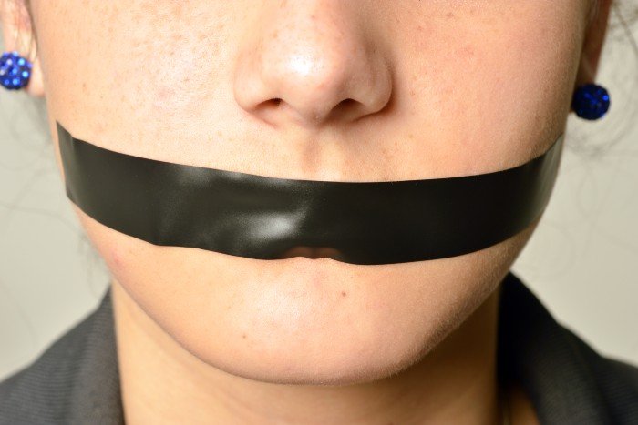 International Women's Day: a woman's mouth with a tape on it