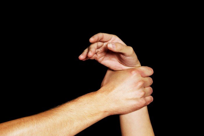 A woman's wrist is held by a man's hand