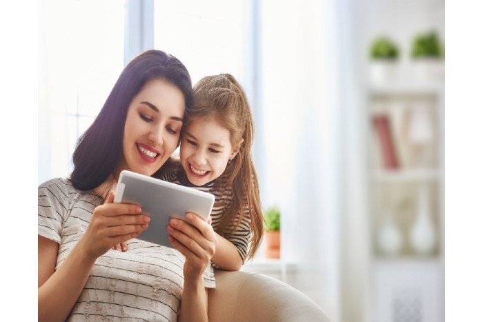 mother's day: mum and daugther taking to someone on the tablet